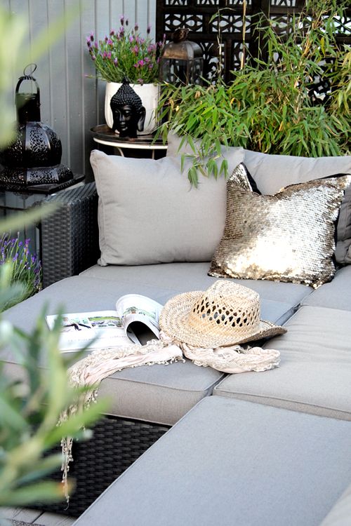 Outdoor couch with cushions and surrounded by plants