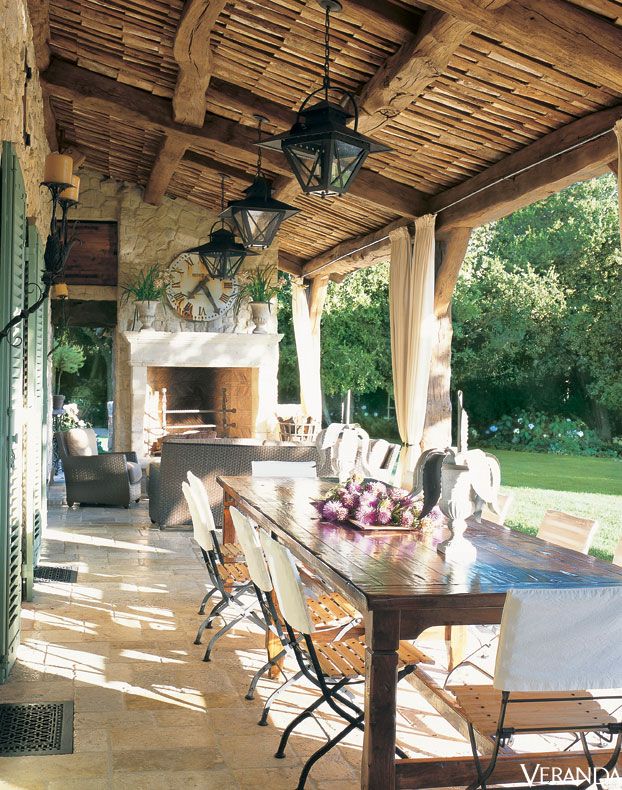 mediterranean veranda with dining table and open fireplace